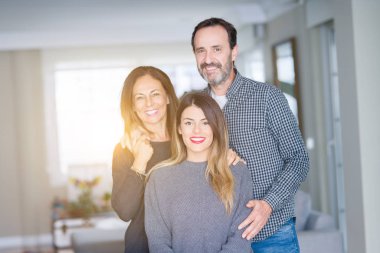 Güzel aile birlikte. Anne, baba ve kızı gülümseyen ve evde sevgi ile sarılma.