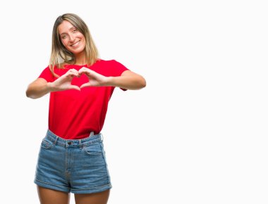 Genç güzel kadın kalp simgesi ve elleriyle şekil gösterilen aşık gülümseyen izole arka plan yüzünden. Romantik kavramı.