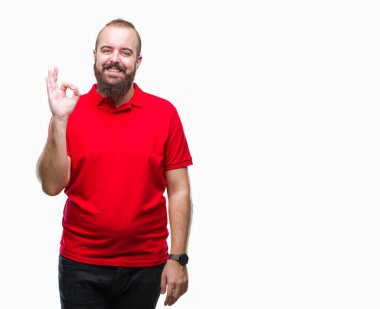 İzole arka plan el ve parmaklar ok işaretiyle yapıyor olumlu gülümseyen üzerinde kırmızı gömlek giyen genç beyaz hipster adam. Başarılı ifade.