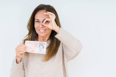 50 pound banknot ile mutlu yüz el parmaklarının arasından seyir göz üzerinde ok işaretiyle yapıyor gülümseyen izole arka plan üzerinde tutan orta yaş kadın