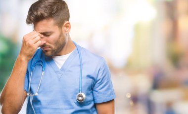 Genç yakışıklı izole arka plan üzerinde yorgun gözleri duygu yorgunluk ve baş ağrısı ve burun sürtme cerrah adam doktor. Stres ve hayal kırıklığı kavramı.