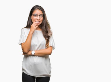 Stresli ve gergin elle çivi ısırma ağzına bakarak izole arka plan üzerinde gözlük takan genç güzel Arap kadın. Anksiyete sorunu.