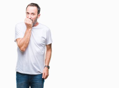 Orta yaş ağarmış üst düzey adam stresli ve gergin ile izole arka plan üzerinde beyaz t-shirt giyen tırnak ısırma dudaklarından eller. Anksiyete sorunu.