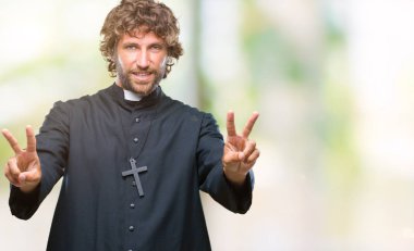 Zafer işareti yapıyor parmak gösterilen kamera seyir gülümseyen izole arka plan yakışıklı İspanyol Katolik rahip adam. İki numaralı.