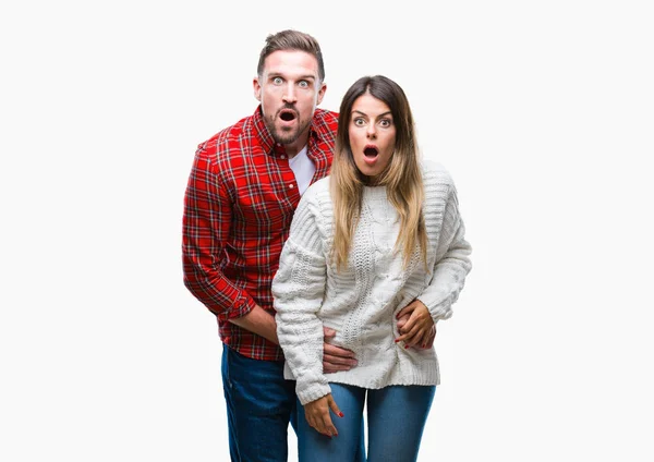 驚きの表現 恐怖と興奮した顔でショックを受けて孤立した背景に冬のセーターを着ている愛の若いカップル — ストック写真