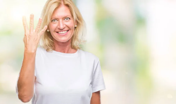 中年金发女人在孤立的背景显示 并指出手指数四 而微笑着自信和快乐 — 图库照片
