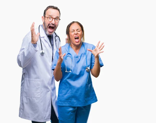 中年西班牙医生的伴侣夫妇穿着医疗制服在孤立的背景疯狂和疯狂的喊话和大喊大叫 积极的表情和手臂抬起来 挫折的概念 — 图库照片
