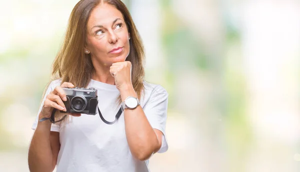 中年西班牙妇女拍照用老式的照片相机在孤立的背景严重的脸思考问题 非常混乱的想法 — 图库照片