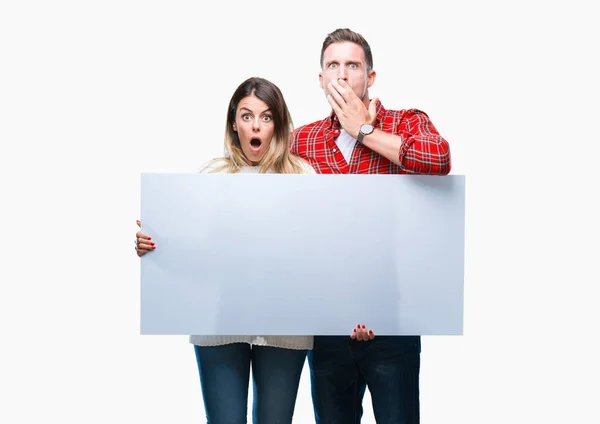 Young Couple Together Holding Blank Banner Isolated Background Cover Mouth — Stock Photo, Image