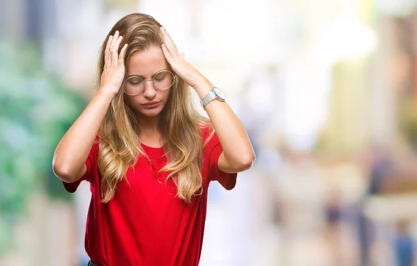 若い美しいブロンドの女性ため必死と強調した頭痛に苦しんで孤立の背景に眼鏡をかけてのの痛みと片頭痛 頭に手 — ストック写真