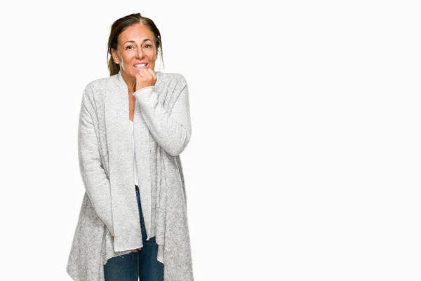 美しい中年成人女性の不安や両手の爪を噛んで口の中で緊張を探して孤立の背景に冬のセーターを着ています 不安の問題 — ストック写真