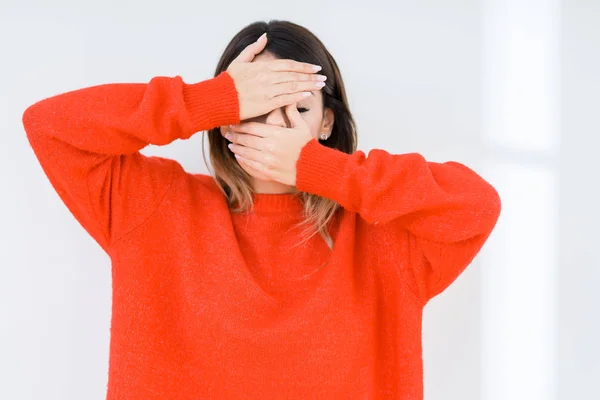 孤立した背景は 目を覆っていると手と口の上のカジュアルな赤いセーターを着た若い女性は驚きし ショックを受けた 感情を隠す — ストック写真