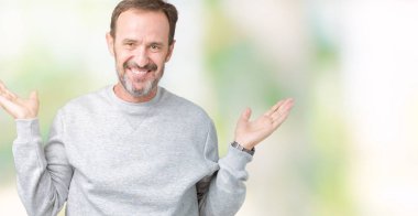 Gülen iki elle gösterilen açık avuç içi, sunma ve karşılaştırma ve denge reklam arka plan üzerinde bir kazak giymiş yakışıklı orta yaş komuta sizde izole