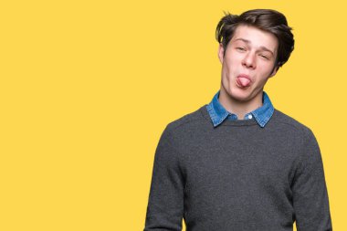 Genç yakışıklı zarif adam dilini izole arka plan üzerinde out komik ifade ile mutlu. Duygu kavramı.