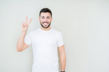 Yakışıklı delikanlı gösterilen ve parmakları ile işaret izole arka plan üzerinde rahat beyaz t-shirt giyen ikincisi ise kendinden emin ve mutlu gülümseyerek.