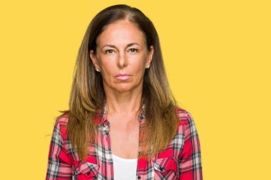 Yüzünde ciddi bir ifade ile izole arka plan üzerinde rahat forması giyen orta yaş yetişkin kadın. Basit ve doğal kameraya bakıyor.