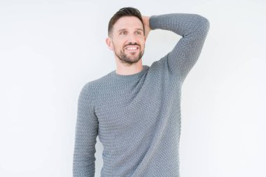 El hareketi ile kendine güvenen dokunaklı saç gülümseyerek, çekici poz izole arka plan üzerinde rahat kazak giyen genç yakışıklı adam