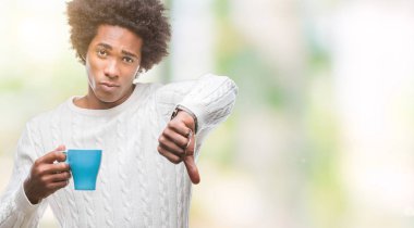 Kızgın yüz, eksi işareti aşağı antipati başparmak ile gösterilen, ret kavramı ile izole arka plan üzerinde kahve içme Afro Amerikalı adam