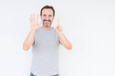 Üst düzey yakışıklı gösteren ve parmakları ile işaret izole arka plan üzerinde kendinden emin ve mutlu gülümseyerek süre 6 numara.