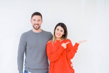 Genç güzel çift togheter üzerinden hayran ve el ile sunulması ve parmak ile işaret ederken kameraya gülümseyen izole arka plan.