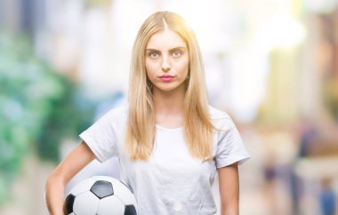 Acımak yüz ciddi düşünüyorum üstünde kendine güvenen bir ifade ile izole arka plan üzerinde futbol topu tutan genç güzel sarışın kadın