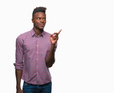 Kameraya bakarak yan el ve parmak ile işaret eden genç Afro-Amerikan adam yüzünde kocaman bir gülümseme ile izole arka plan üzerinde.