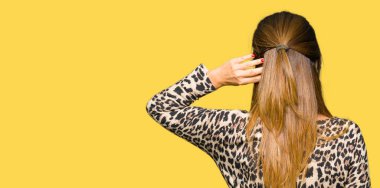 Leopar hayvan baskı elbise geriye düşünme hakkında şüphe el ile kafasına giyen güzel orta yaş kadın