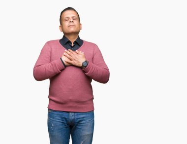 Orta yaş Arap adam ile gülümseyen izole arka plan üzerinde kapalı gözler ve yüzünde minnettar jest ile göğüs üzerinde eller. Sağlık kavramı.