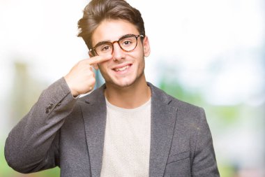 Genç iş adamı gözlük izole üzerinde işaretleme için yüz ve burun, neşeli gülümseyerek el parmak ile arka plan