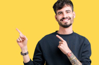 Yakışıklı delikanlı gülümseyen ve iki elleri ve parmakları ile tarafına işaret kamera bakarak izole arka plan üzerinde.
