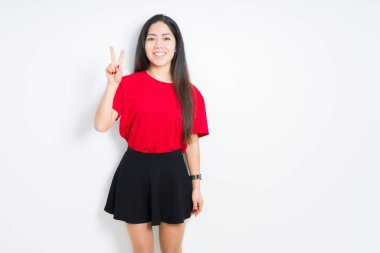 Gösterilen ve parmakları ile işaret izole arka plan üzerinde kırmızı t-shirt ve etek giyen güzel esmer kadın ikincisi ise kendinden emin ve mutlu gülümseyerek.