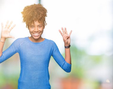 Güzel genç Afro-Amerikan kadın gösterilen ve parmakları ile işaret izole arka plan üzerinde numara 9 kendinden emin ve mutlu gülümseyerek süre.