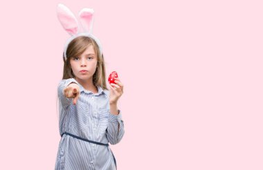 Kamera ve size, el işareti, pozitif ve kendinden emin bir jest ön parmak ile işaret Paskalya bunny kulaklar giyen genç sarışın çocuk