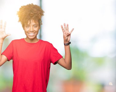 Güzel genç Afro-Amerikan kadın gösterilen ve parmakları ile işaret izole arka plan üzerinde numara 9 kendinden emin ve mutlu gülümseyerek süre.