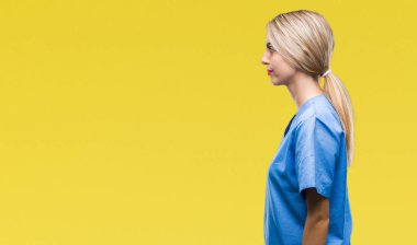 Genç güzel sarışın doktor cerrah hemşire kadın izole arka tarafa bakarak dinlenmek doğal yüz emin gülümseme ile pozuyla profil.