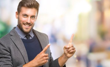 Genç yakışıklı iş adamı gülümseyen ve iki elleri ve parmakları ile tarafına işaret kamera bakarak izole arka plan üzerinde.