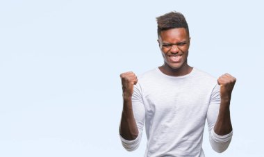 İzole arka plan kutlama üzerinde genç Afro-Amerikan adam şaşırttı ve başarı için kaldırdı kollarını açarak hayret ve gözleri açık. Kazanan kavramı.