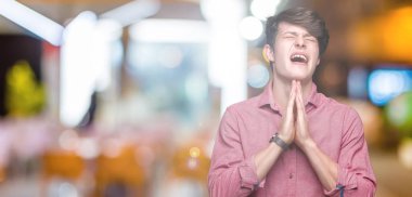 Genç yakışıklı iş adamı yalvarıyor ve umut ifade yüzünde çok duygusal ve endişe ile birlikte elleriyle dua izole arka plan üzerinde. Bağışlanmak. Din kavramı.