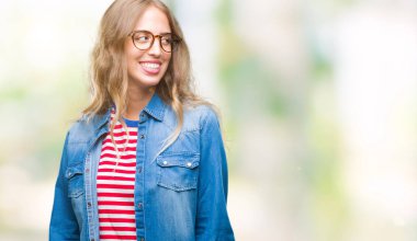 Uzak tarafına yüzünde, doğal ifade gülümseme ile seyir izole arka plan üzerinde gözlük güzel sarışın genç kadın. Kendine güvenen gülüyor.