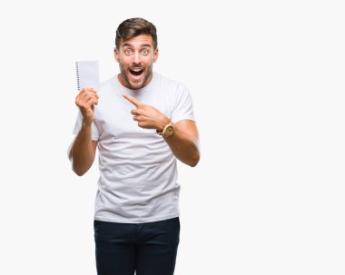 Defter izole arka plan üzerinde çok mutlu el ve parmak ile işaret tutan genç yakışıklı adam