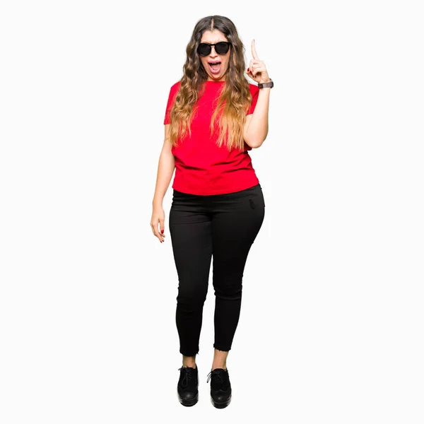 Junge Schöne Frau Rotem Shirt Und Sonnenbrille Mit Erhobenem Zeigefinger — Stockfoto