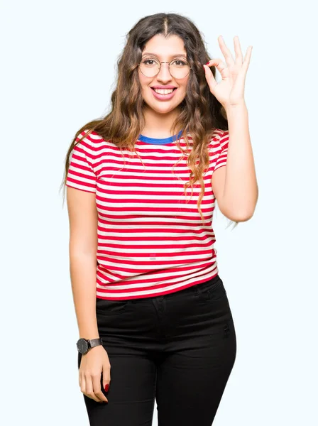 Jovem Mulher Bonita Usando Óculos Sorrindo Positivo Fazendo Sinal Com — Fotografia de Stock