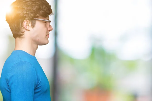 Young man wearing funny thug life glasses over isolated background looking to side, relax profile pose with natural face with confident smile.