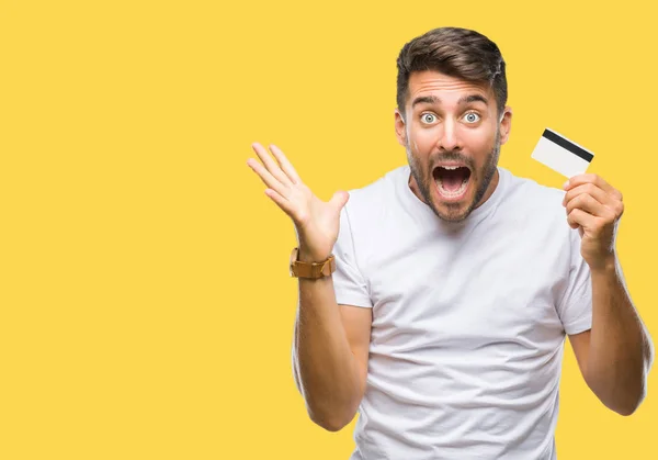 Joven Hombre Guapo Sosteniendo Tarjeta Crédito Sobre Fondo Aislado Muy —  Fotos de Stock