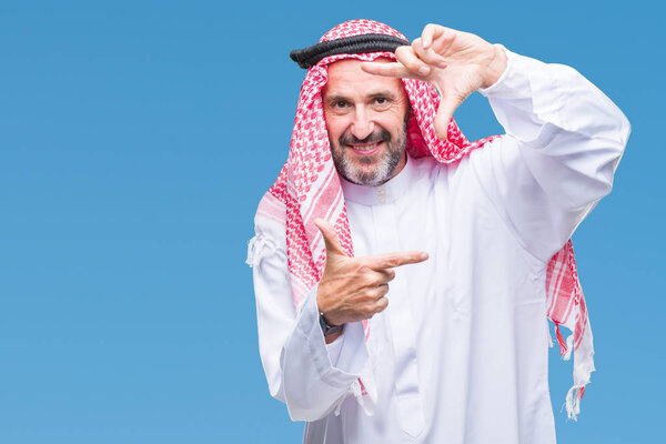 Senior arab man wearing keffiyeh over isolated background smiling making frame with hands and fingers with happy face. Creativity and photography concept.