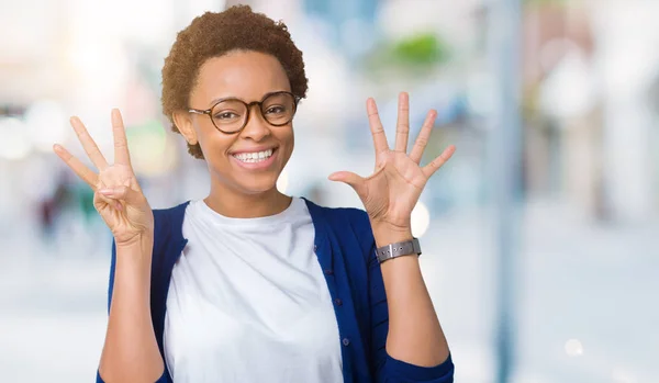 若いアフリカ系アメリカ人美女分離背景表示と指で上向きに眼鏡をかけて数 自信を持って 幸せな笑みを浮かべて — ストック写真