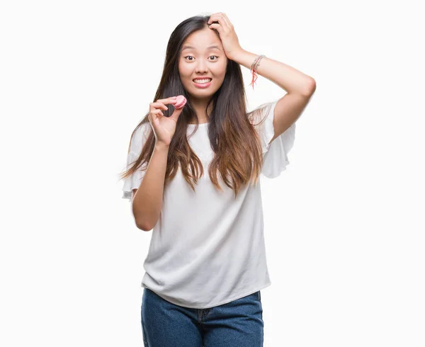 Young Asian Woman Eating Pink Macaron Sweet Isolated Background Stressed — Stock Photo, Image