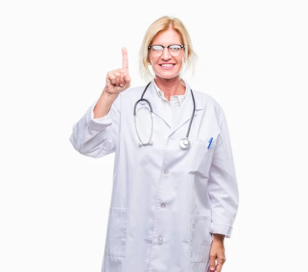中年金发碧眼的医生妇女在孤立的背景显示和手指第一指向 而微笑着自信和快乐 — 图库照片
