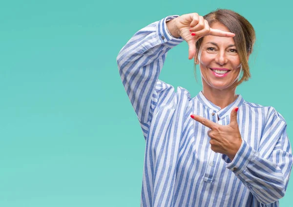 Orta yaş İspanyol kadın kıdemli elle yapma çerçeve ve parmakları ile mutlu yüz gülümseyen izole arka plan üzerinde. Yaratıcılık ve Fotoğrafçılık kavramı.