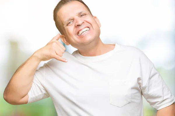 中年阿拉伯男子穿白色 T恤在孤立的背景微笑着做电话手势用手和手指喜欢在电话交谈 传达概念 — 图库照片